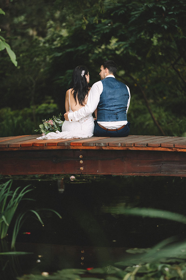 couple sitting on bridge in garden